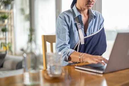 Injured woman working on laptop